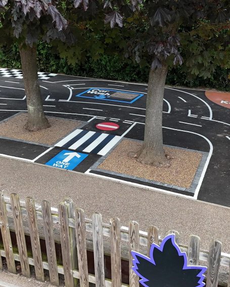 Playground road layout with trees, pedestrian crossings, and traffic signs.