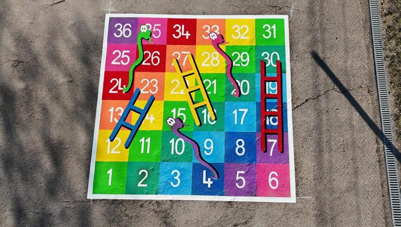 Colourful Snakes and Ladders board with numbered squares and bright graphics.