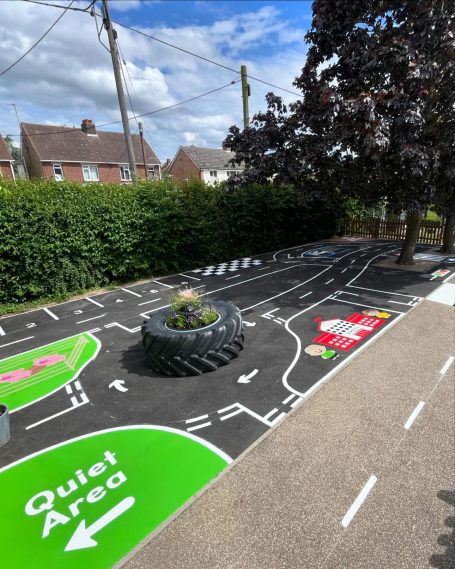 Playground area with road markings, a quiet zone, and a central flowered tyre feature.