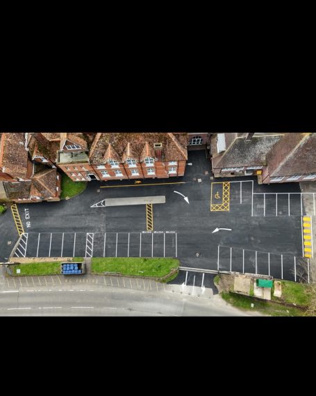Aerial view of an empty parking lot beside residential buildings.