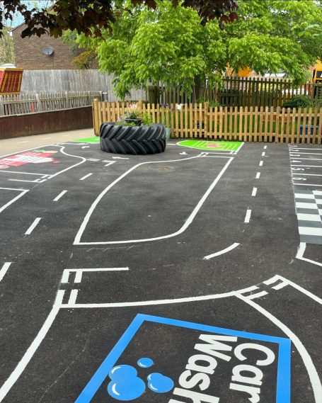 Playground with road markings, a tyre obstacle, and a car wash area.