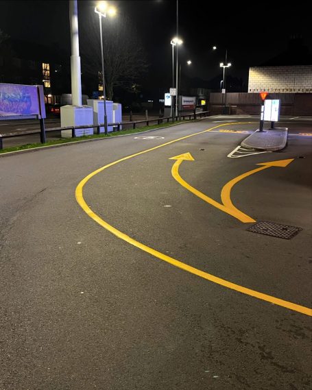 Curved yellow arrows indicate a driving route in a dimly lit area at night.